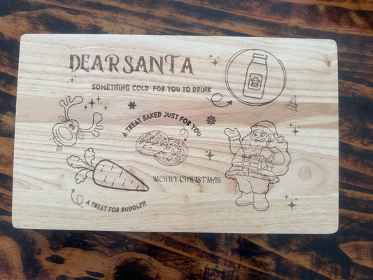 Wooden plaque with Christmas-themed illustrations and text on a wooden surface