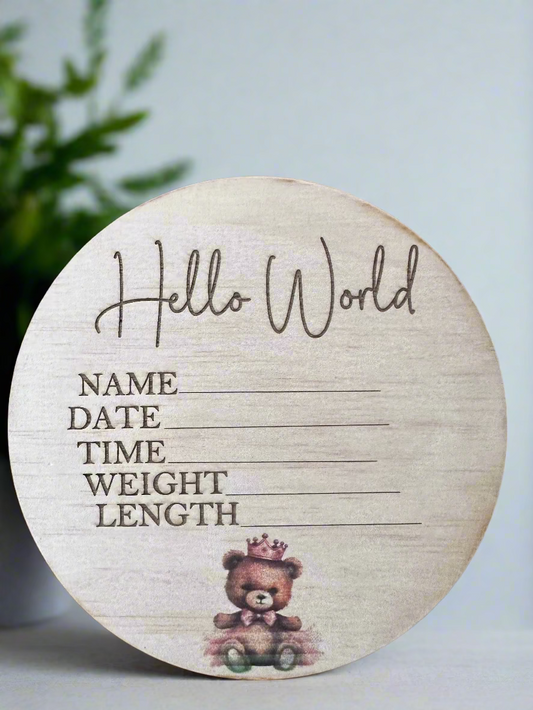Wooden disc with engraved baby details and floral designs on a white background.